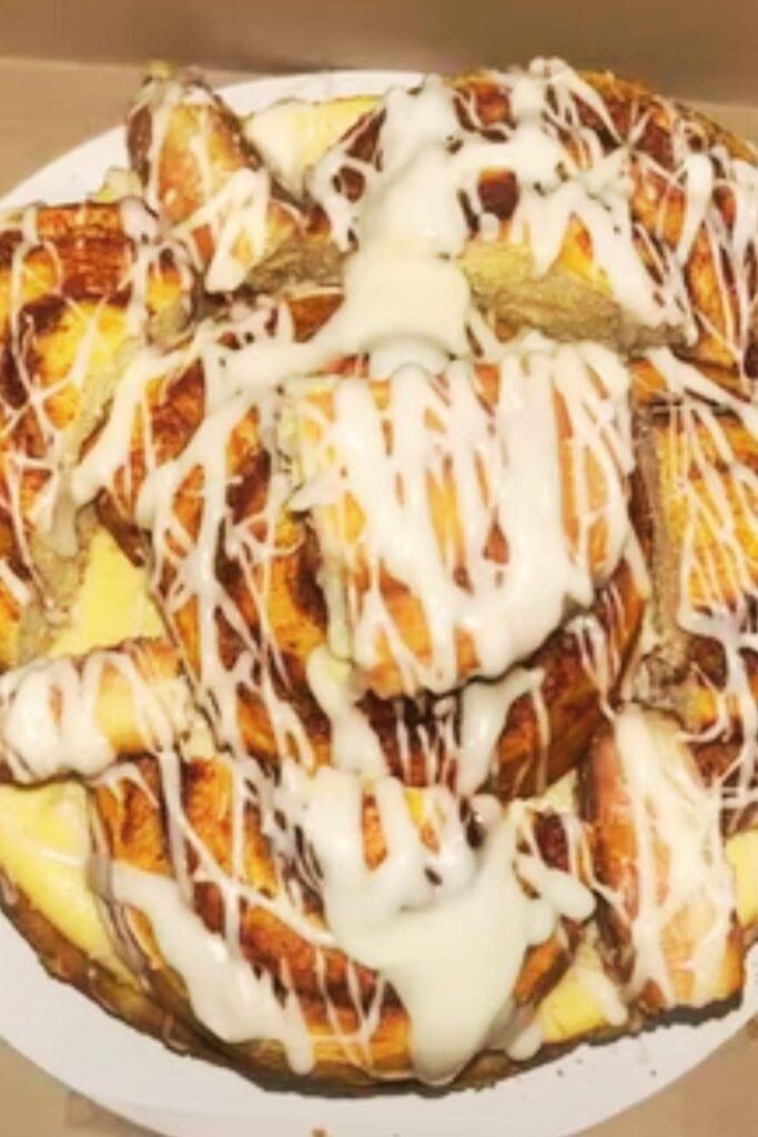 Golden honeybun glaze being drizzled over finished cheesecake